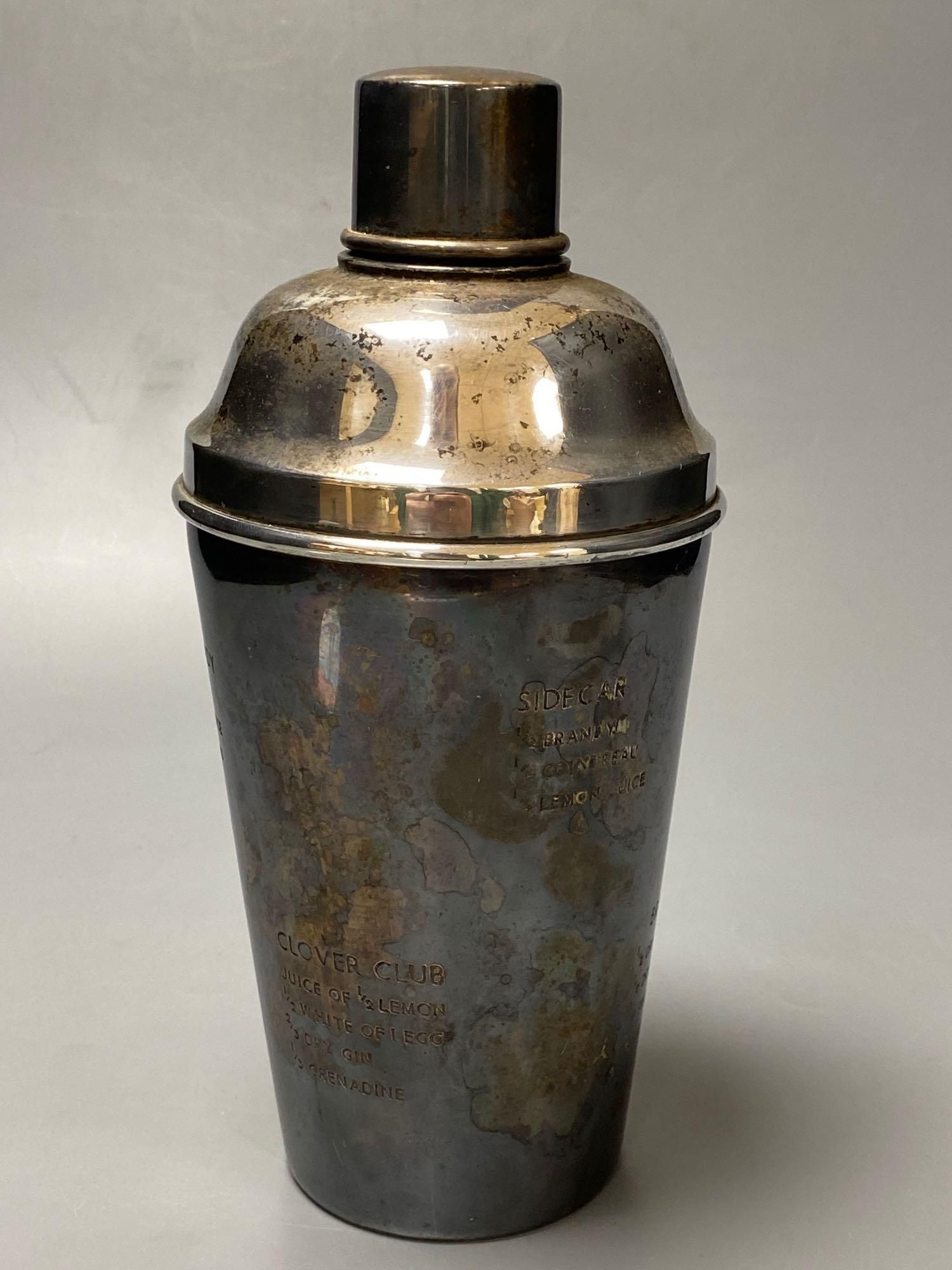 A plated cocktail shaker with recipes, a chrome Spirit of Ecstasy style car mascot on metal base and wood plinth and sundries,